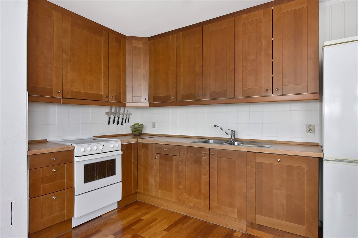 Innredningen har profilerte fronter, benkebelysning, lyse fliser over benk og heltre benkeplate med dobbel vaskekum. Galleribilde