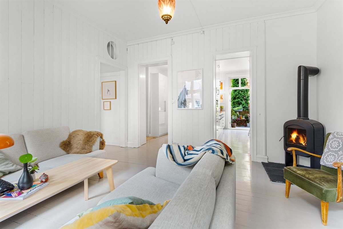 Med vakre originale tregulv, dekorativ stukkatur og rosett samt brede fotlister byr dette rommet på mye sjarm. Peisen skaper kos og hygge på kalde vinterdager. Galleribilde
