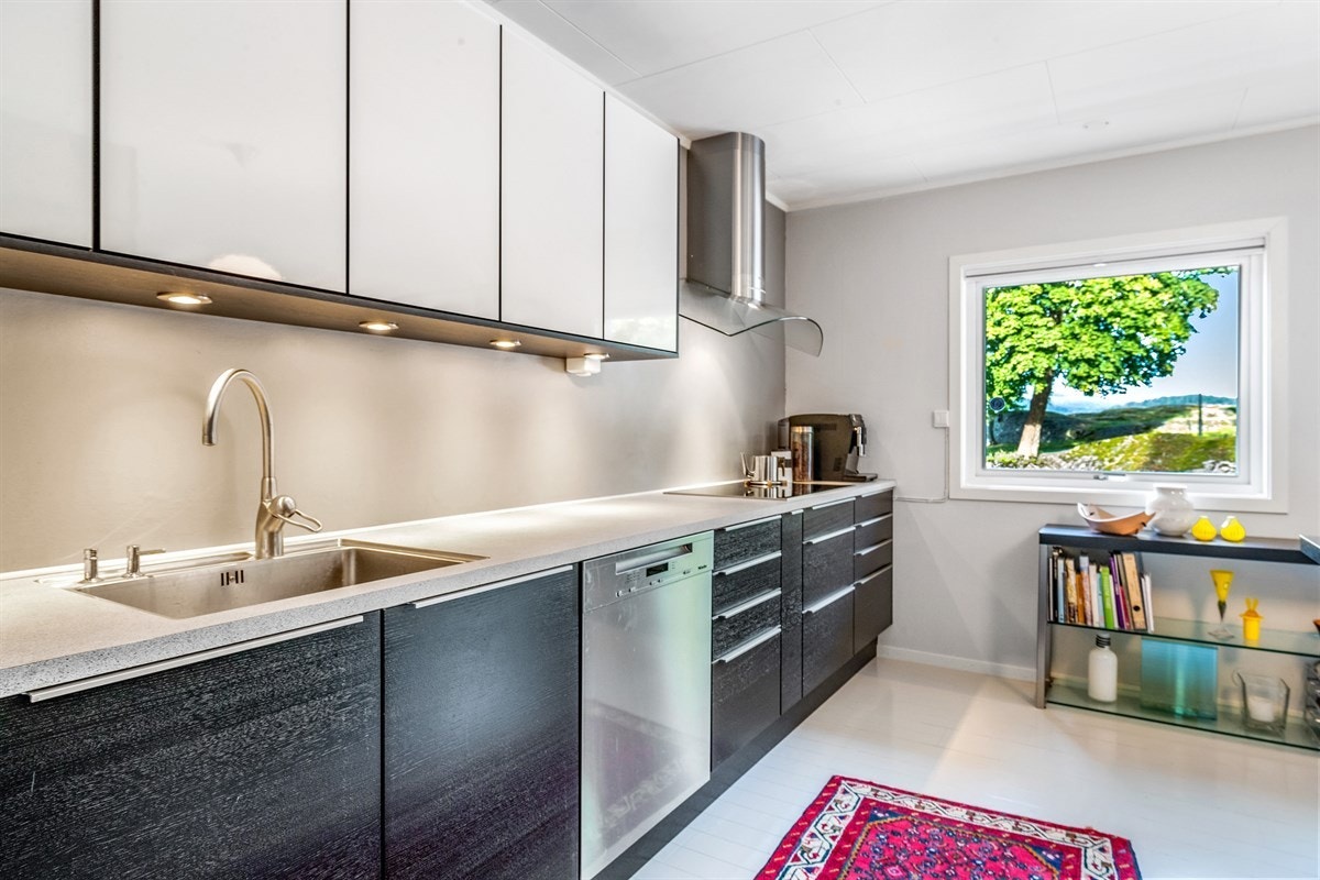 Kjøkkeninnredning med god skapplass og underlimt vask Galleribilde