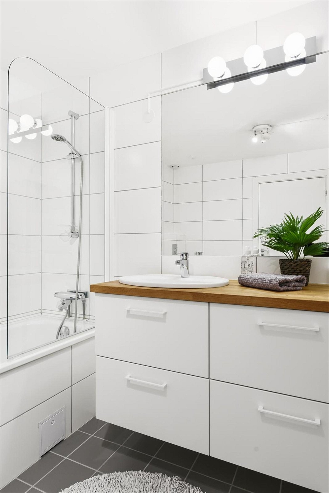 Stort og fint flislagt bad som ligger nærmest soverommene inneholder badekar, vegghengt toalett, servantinnredning fra KVIK med eik benkeplate og nedfelt porselenservant. Galleribilde