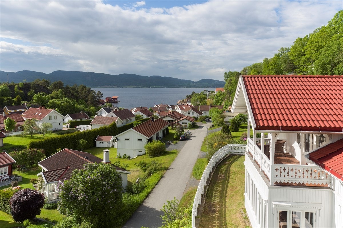 Villaen troner majestetisk i terrenget på høytliggende tomt med nydelig panorama over fjorden, Bakkeskjær, Holmsbusteinene og sentrum. Galleribilde