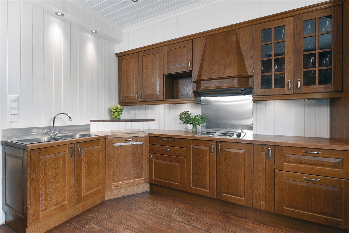 Kjøkkenet har to stekeovner, oppvaskmaskin, koketopp og en pent innkledt ventilator. Det er belysning over benk, stålplate over kokesonen og downlights i himling. Galleribilde