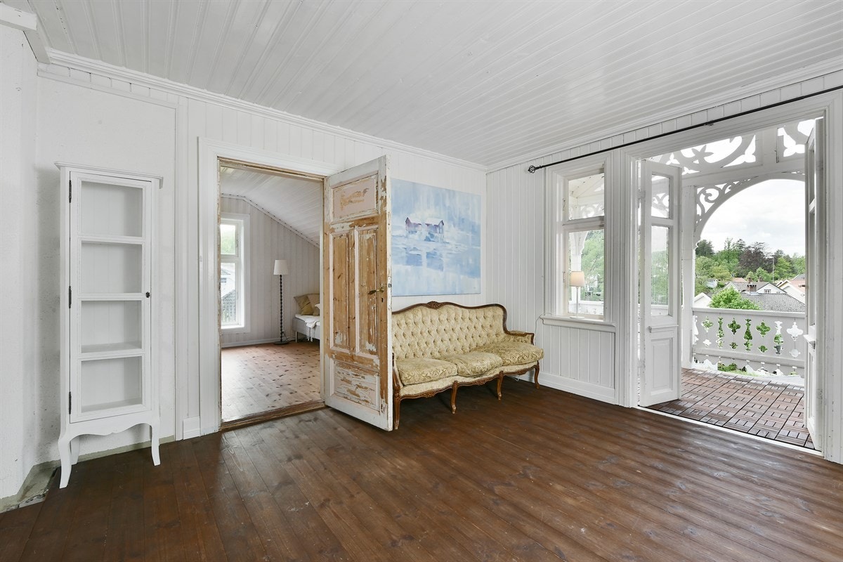 Loftetasjen har en nydelig stue med betydelig sjarm. Rommet har tofløyet glassdør ut til en rikt utsmykket veranda - akkurat slik en ekte sveitservilla bør ha. Galleribilde