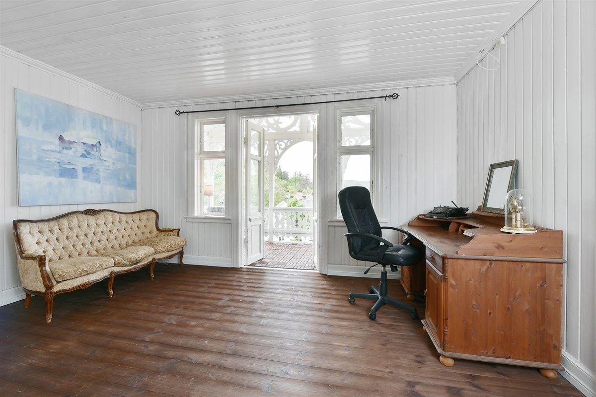 Loftstuen har mørkt tregulv, hvitmalte panelvegger og hvitmalt panelhimling. Den ekstra stuen kan gi fin fleksibilitet og ytterligere privatliv i hverdagen. Galleribilde