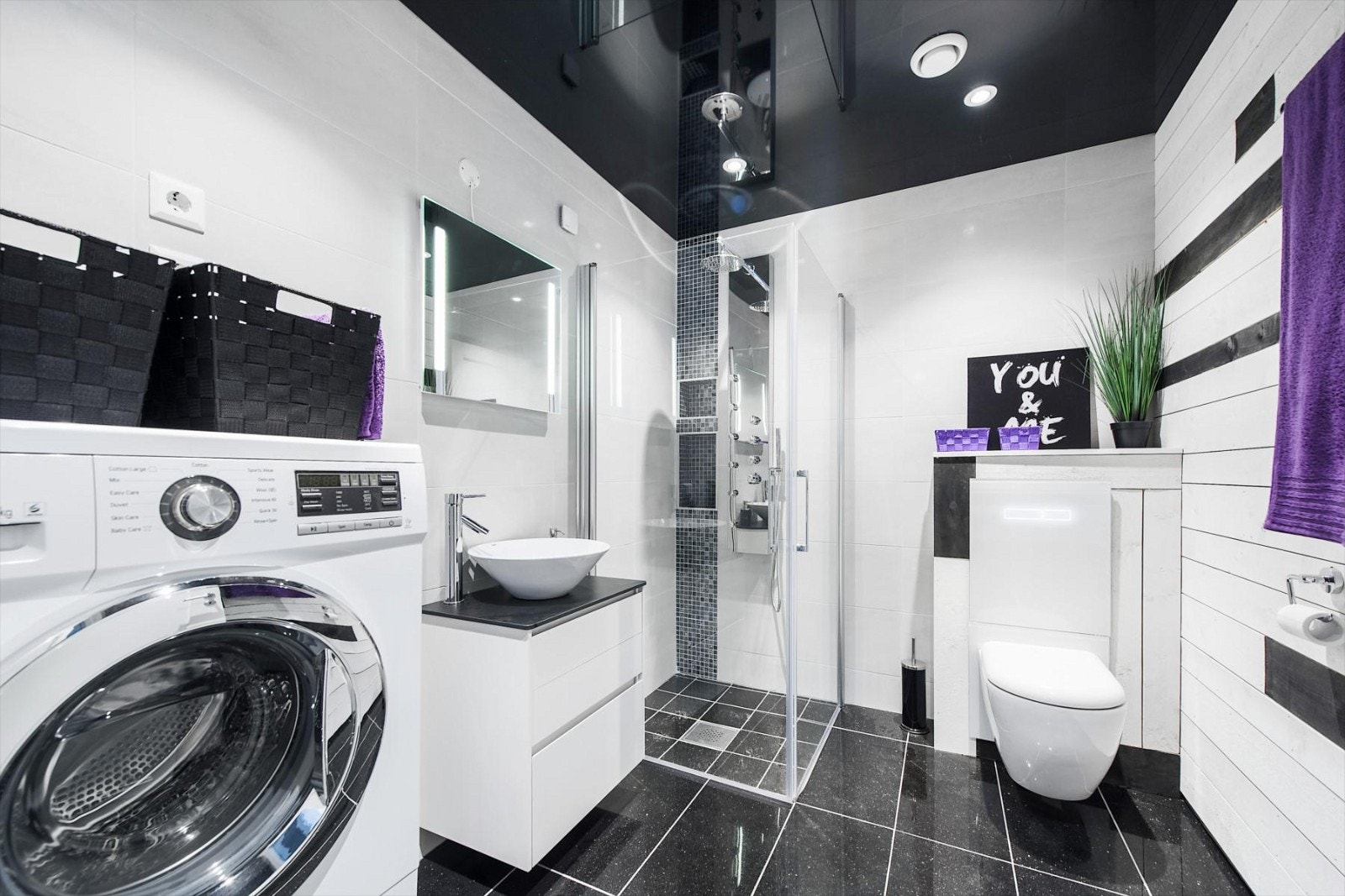 Bad i 1. etasje med gulvvarme og flislagte vegger og gulv, vegghengt klosett, dusjhjørne med innfeldbare glassvegger. Galleribilde