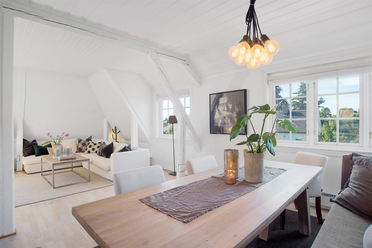 Den åpne løsningen mot kjøkkenet bidrar til rommets luftige atmosfære og det er rikelig med plass for både sofagruppe, tv-løsning og spisebord. Galleribilde