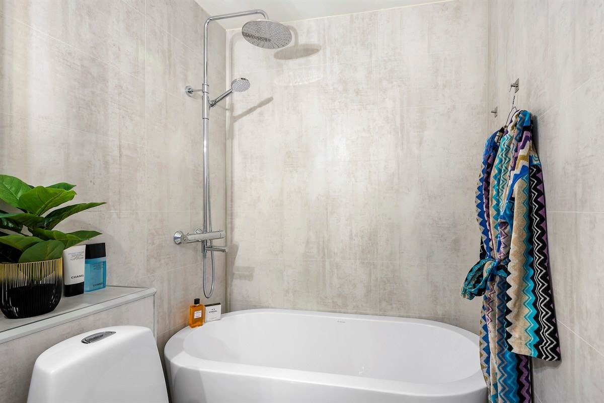 Moderne bad med badekar og opplegg for vaskemaskin. Galleribilde