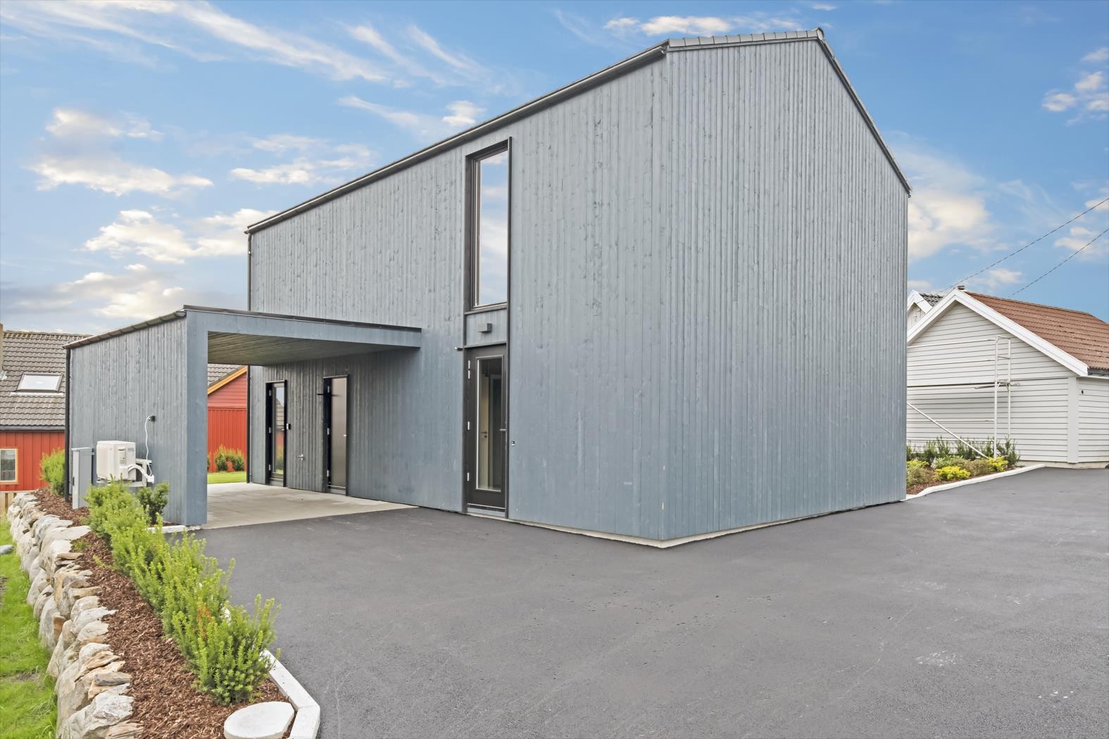 Pent opparbeidet uteareal med plen, busker og stein. Carport, så her kan man gå tørrskodd inn til huset. Galleribilde