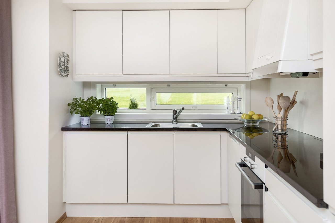 Kjøkkenet har en praktisk L-form og stilren innredning med håndtaksfrie fronter. Her har du selvfølgelig alt av integrerte hvitevarer Galleribilde