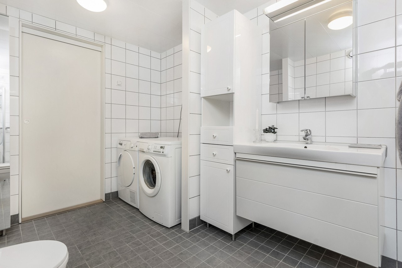 Med innholdsrik baderomsinnredning i både underskap og speilskap med belysning blir morgen og kveldsstellet en ren fornøyelse. Badet har også en praktisk tilliggende bod som med enkle grep blir en flott walk-in-garderobe Galleribilde