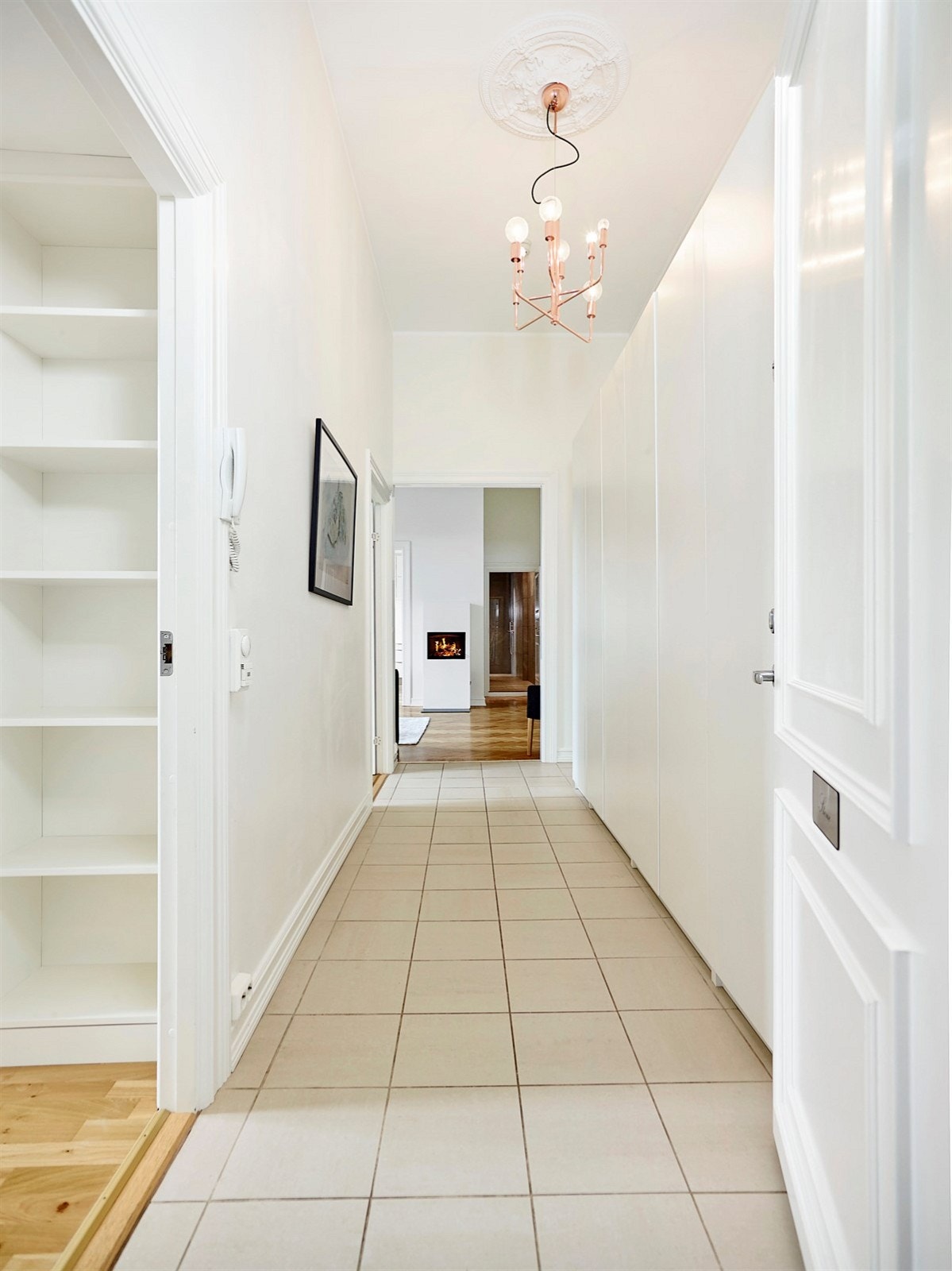 Romslig og innbydende entré med stor garderobe og fliser på gulv. Galleribilde