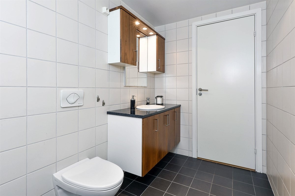 Badet har fliser på gulv og vegger i pene farger. Galleribilde