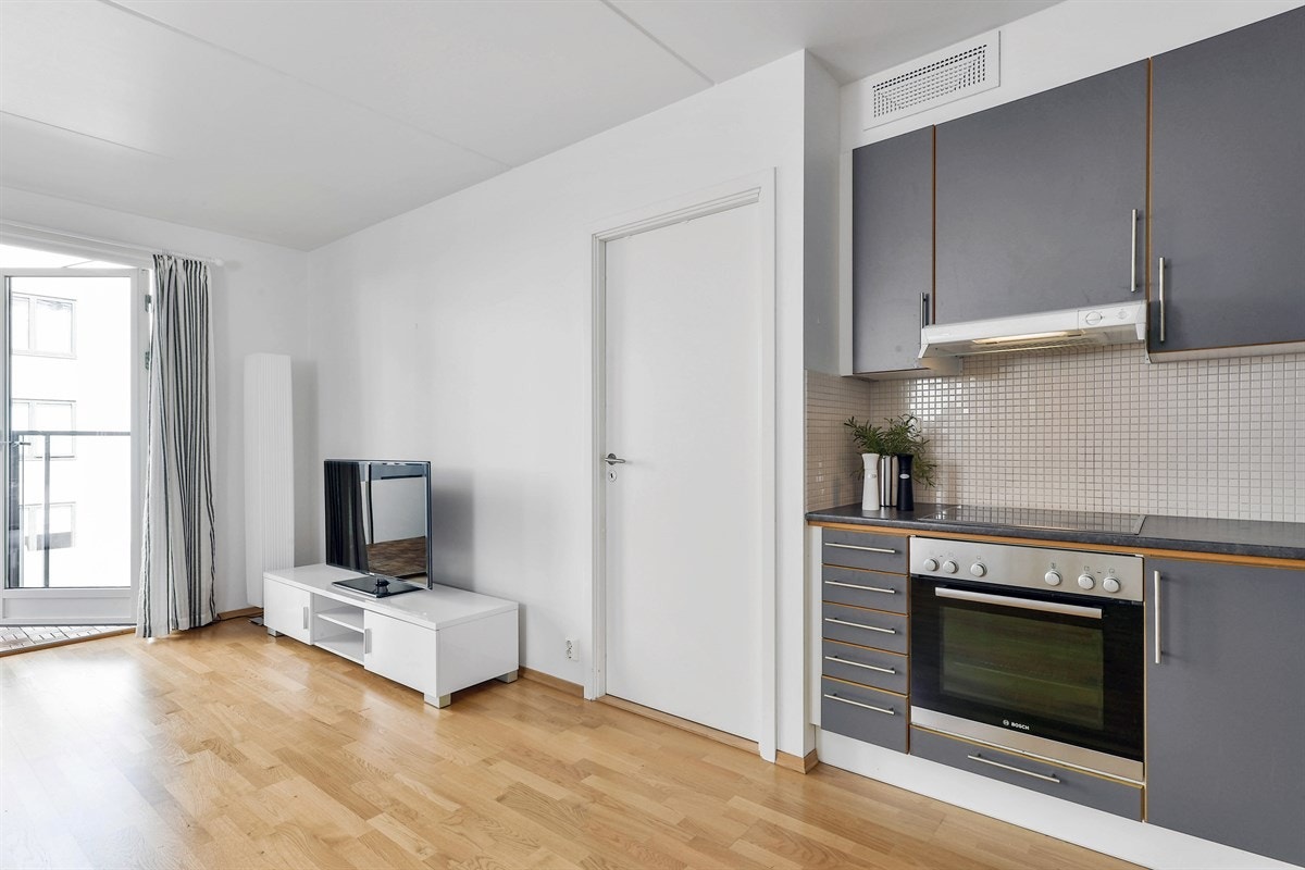 Kjøkkenet ligger åpent i stuen og har en innredning med mørkegrå fronter, som gir en fin kontrast til veggene. Galleribilde