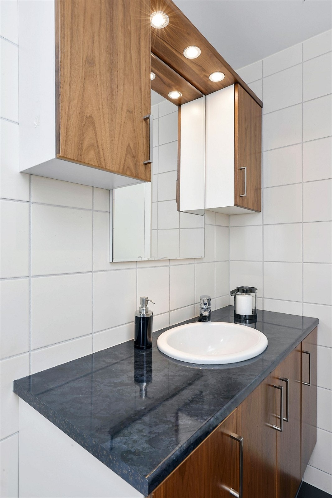 Rommets møblement består av servantskap med tilhørende veggskap og speil med overbelysning. Galleribilde