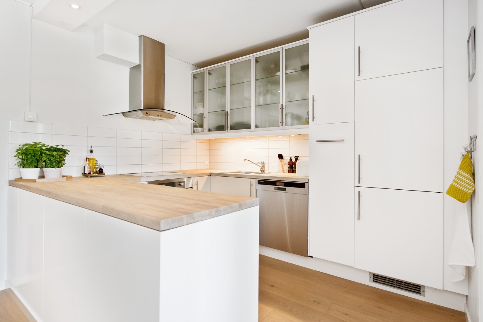 Kjøkkenet er åpent med mye skap og benkeplass Galleribilde