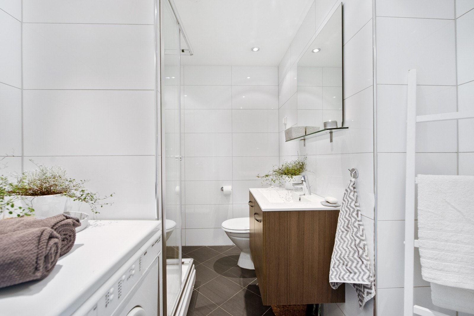 Pent og lyst bad som er flislagt. Opplegg til vaskemaskin Galleribilde