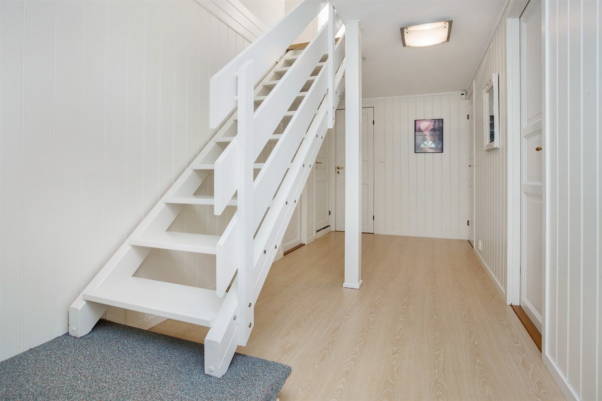 Entreen har en hvitmalt trapp som fører opp til andre etasje. Galleribilde