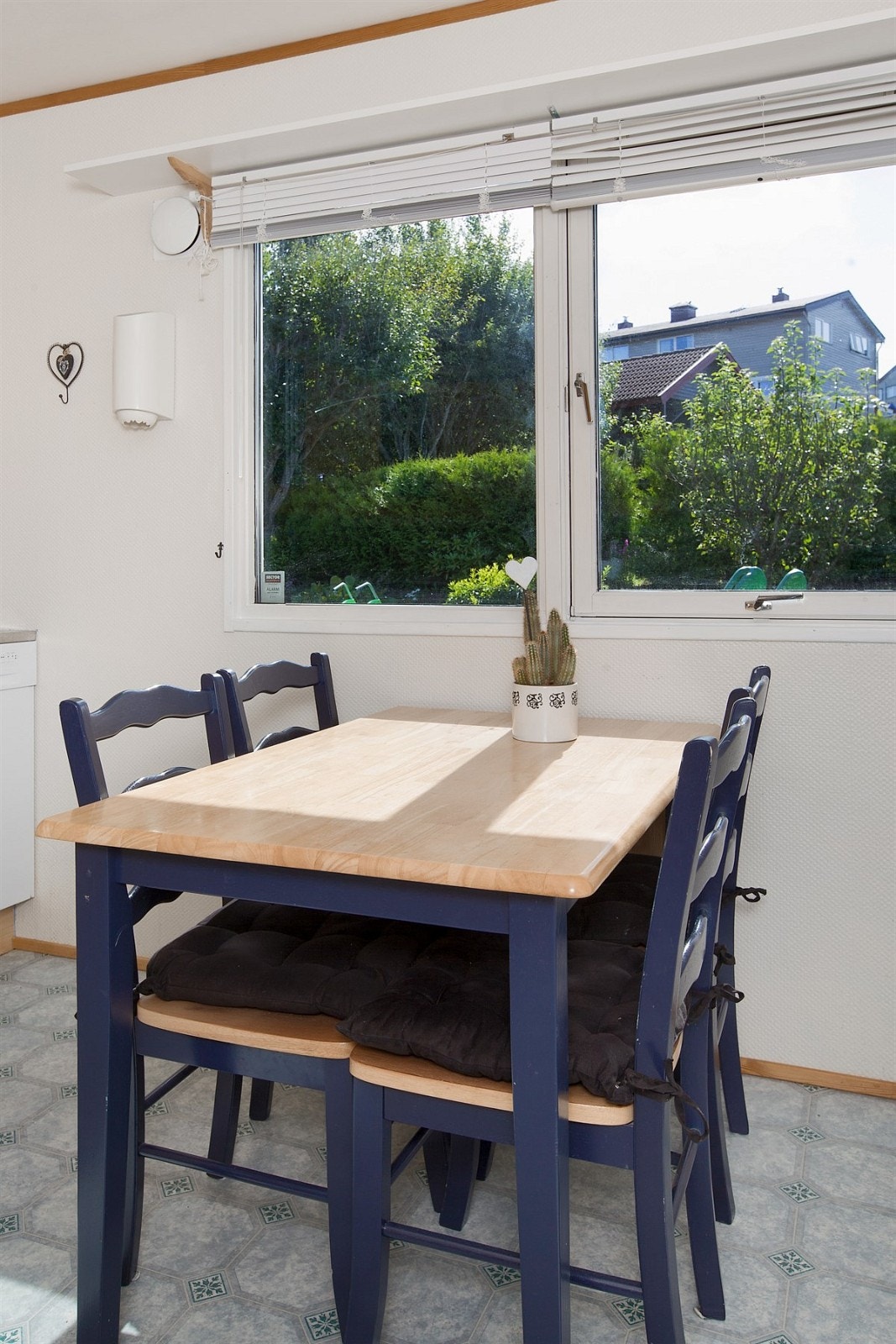 Innredningen har profilerte fronter, vitrineskap og laminert benkeplate med dobbel vaskekum. Det er praktisk designet med god benke- og lagringsplass. Galleribilde