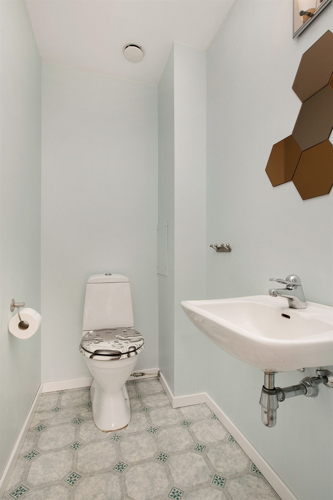 I andre etasje er det en trivelig separat wc. Rommet har gulvbelegg og tapetserte vegger. Det er innredet med frittstående toalett og servant med et stilig speil over. Galleribilde