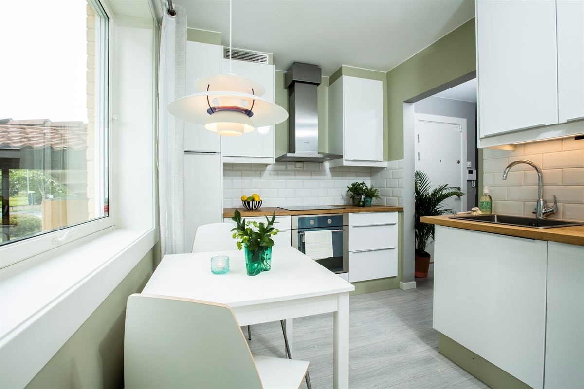 Pent tidsriktig kjøkken med slette fronter i høyglans fra 2016. Benkeplate i tre og integrerte hvitevarer. Galleribilde