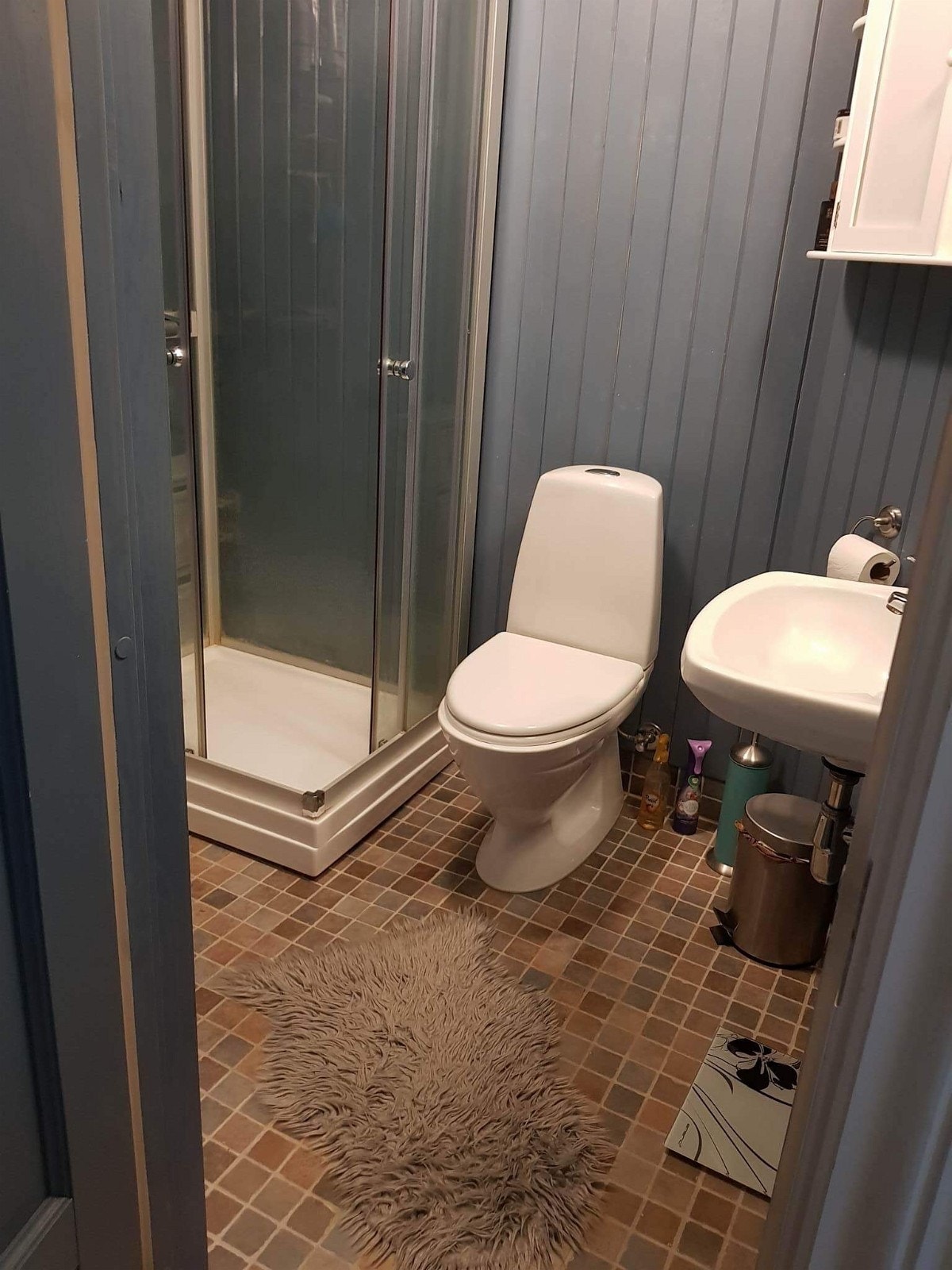 Bad med fliser på gulv og panel på veggene. Vaskemaskin. Galleribilde