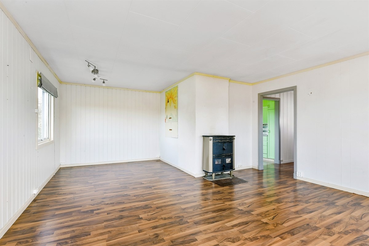 Stuen har hvit himling og god plass for sofaløsning med tilhørende møblement og spisebord. Galleribilde