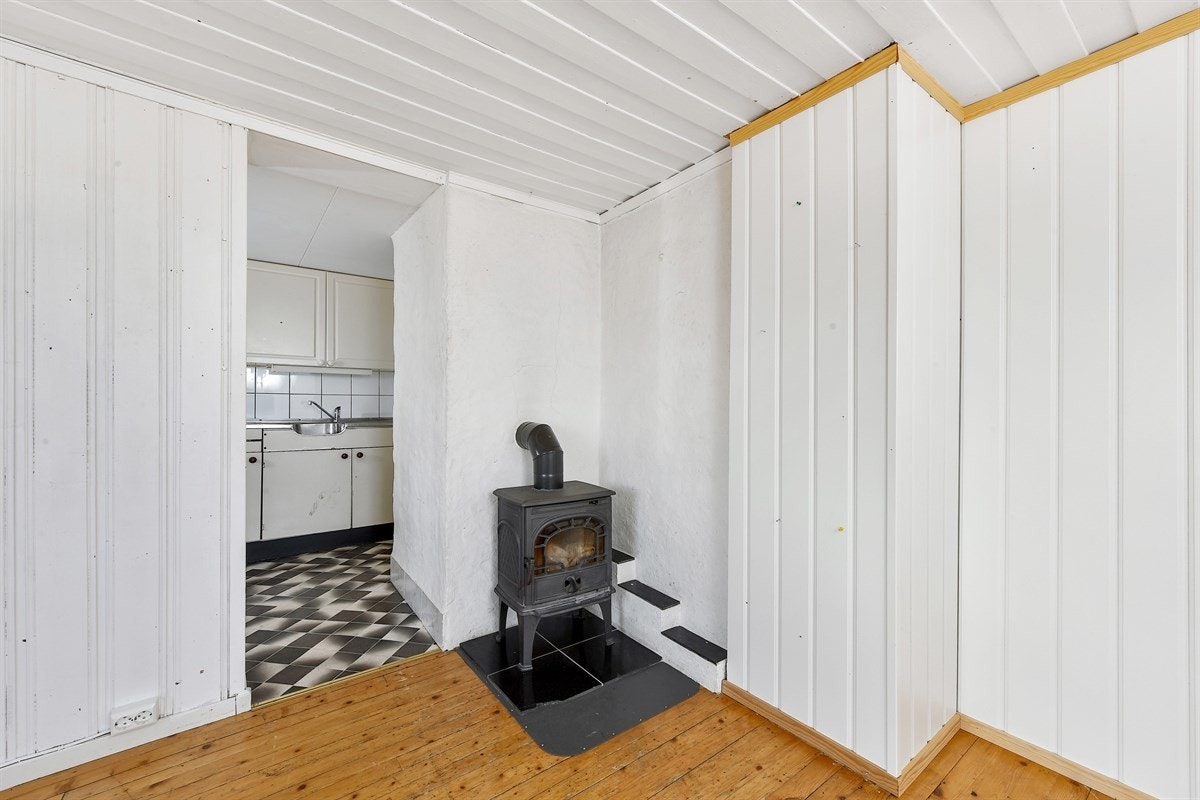 En peisovn er plassert i hjørnet av rommet og sørger for ekstra hygge. Galleribilde