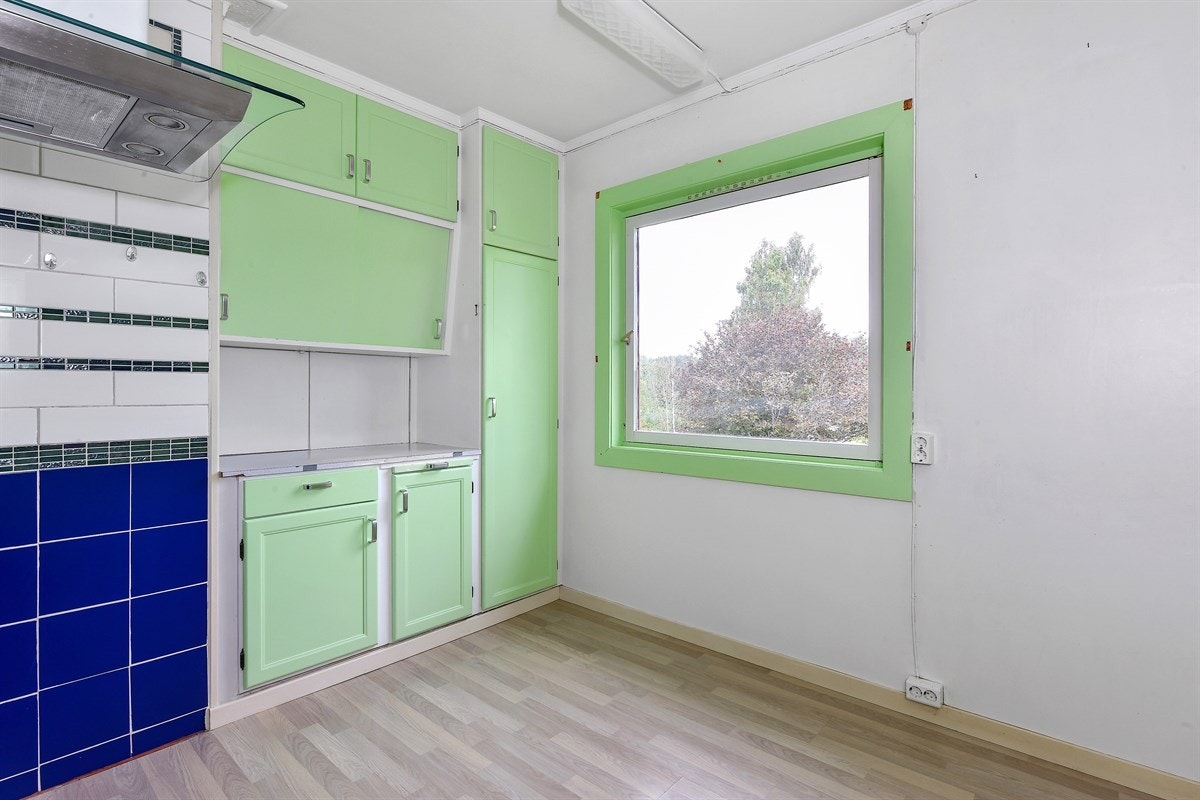 Innredningen på kjøkkenet er plassbygd med grønnmalte og profilerte fronter. Galleribilde