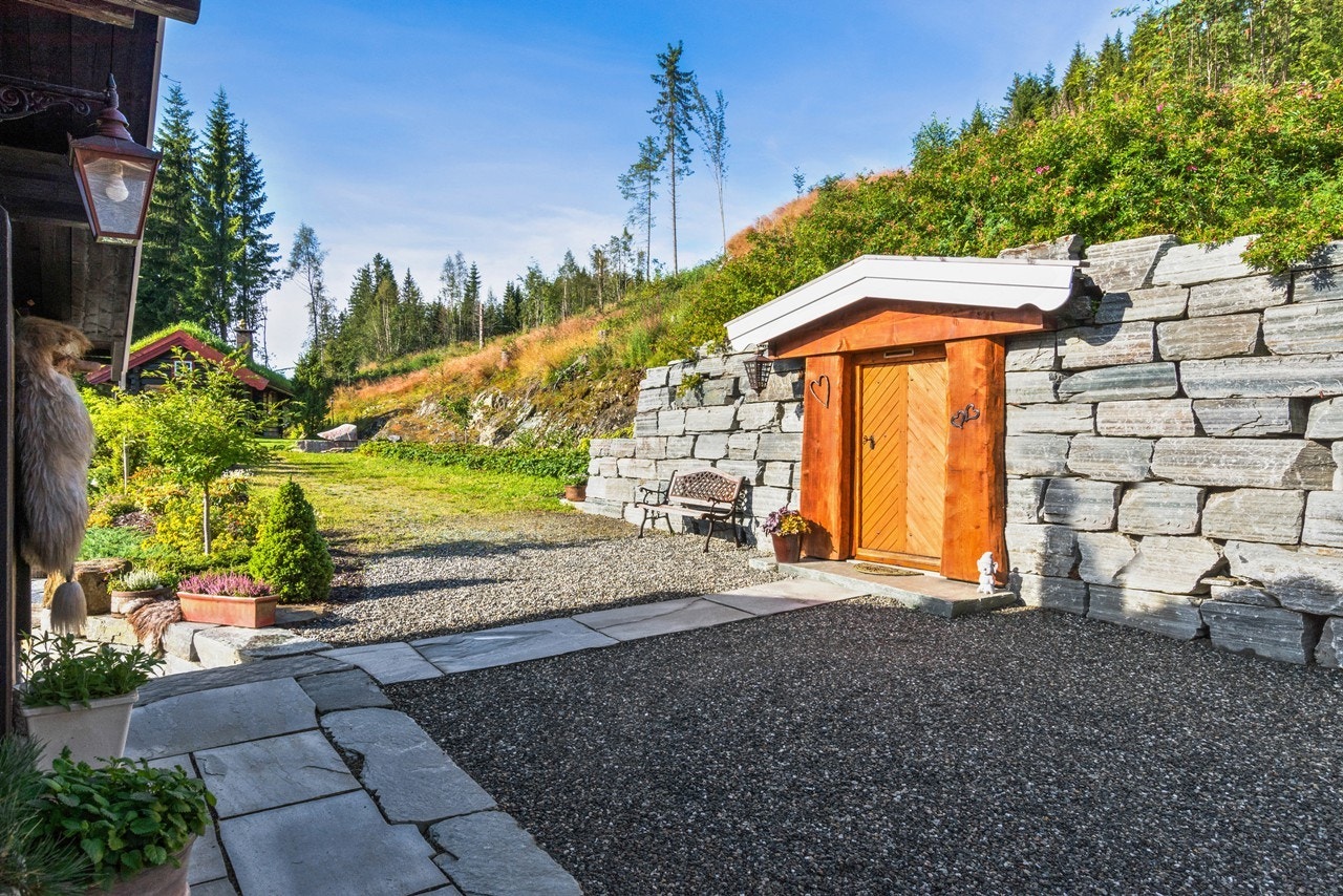 Utvendige fasader er i natursteinsmur og taket er tekket med torv, og er beplantet på tak og sider med div. prydbusker og klatreplanter. Galleribilde