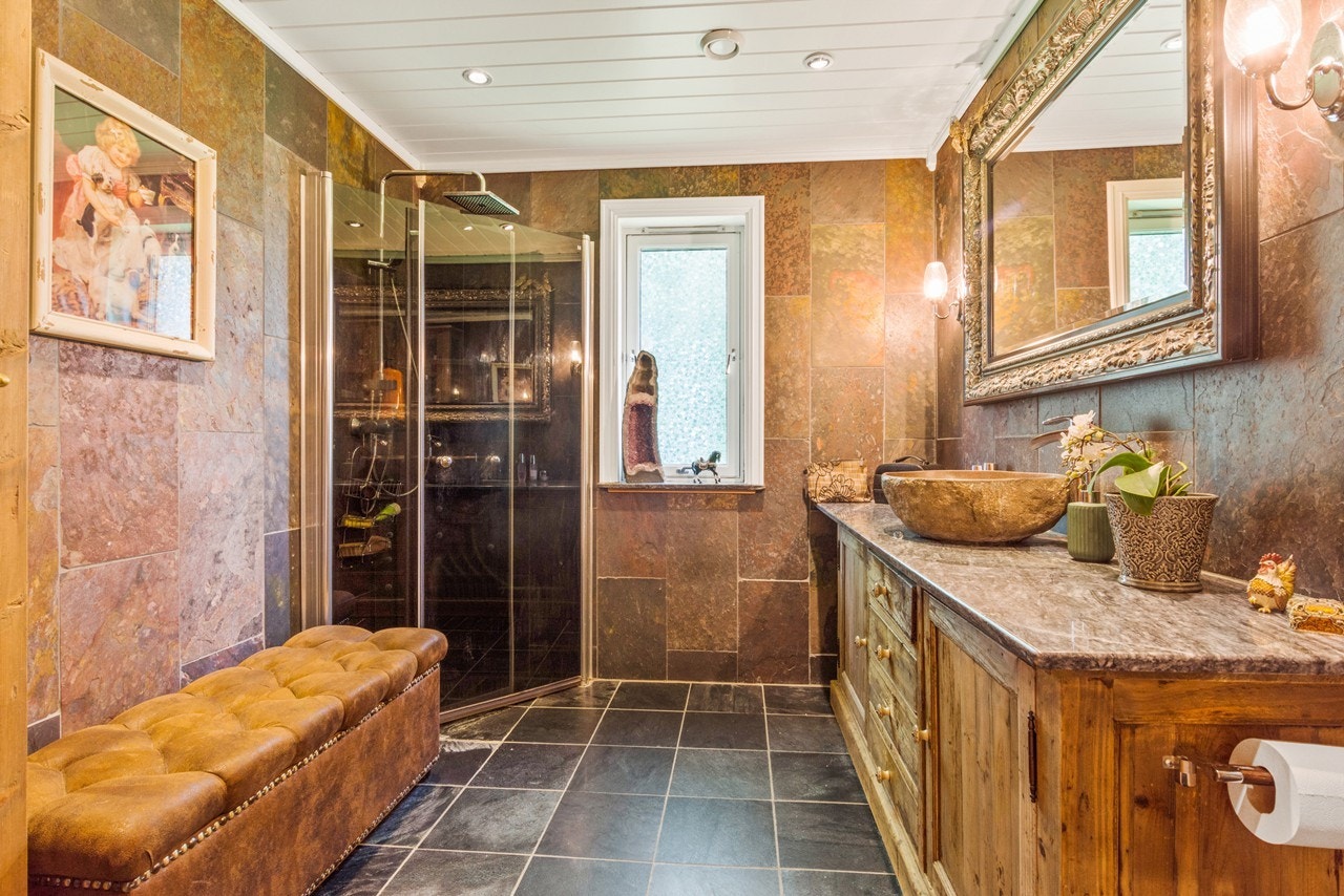 Badet i boligen holder en høy standard - her har du dusjhjørne takdusj med sammenslåbare dusjvegger og en romslig innredning Galleribilde