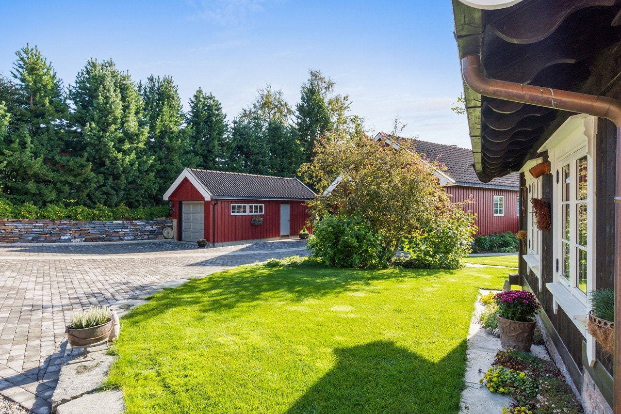 Fra baksthuset mot hovedhuset og garasjen - gårdsplassen er steinlagt sommeren 2017 Galleribilde