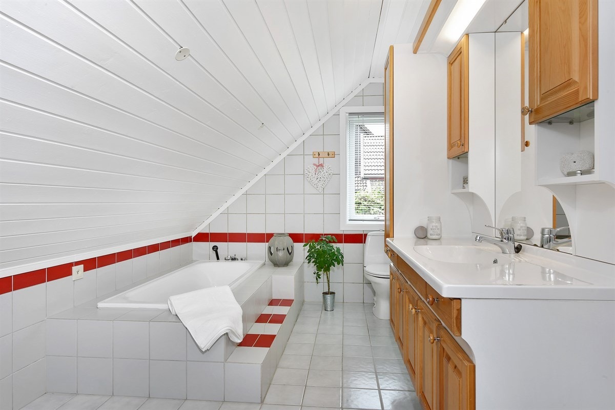 Boligen inneholder to bad, samt et separat toalettrom og et kombinert vaskerom og bad. På badet i tredje etasje er gulv og vegger lagt med lyse fliser, hvorav veggflisene har røde detaljer. Galleribilde