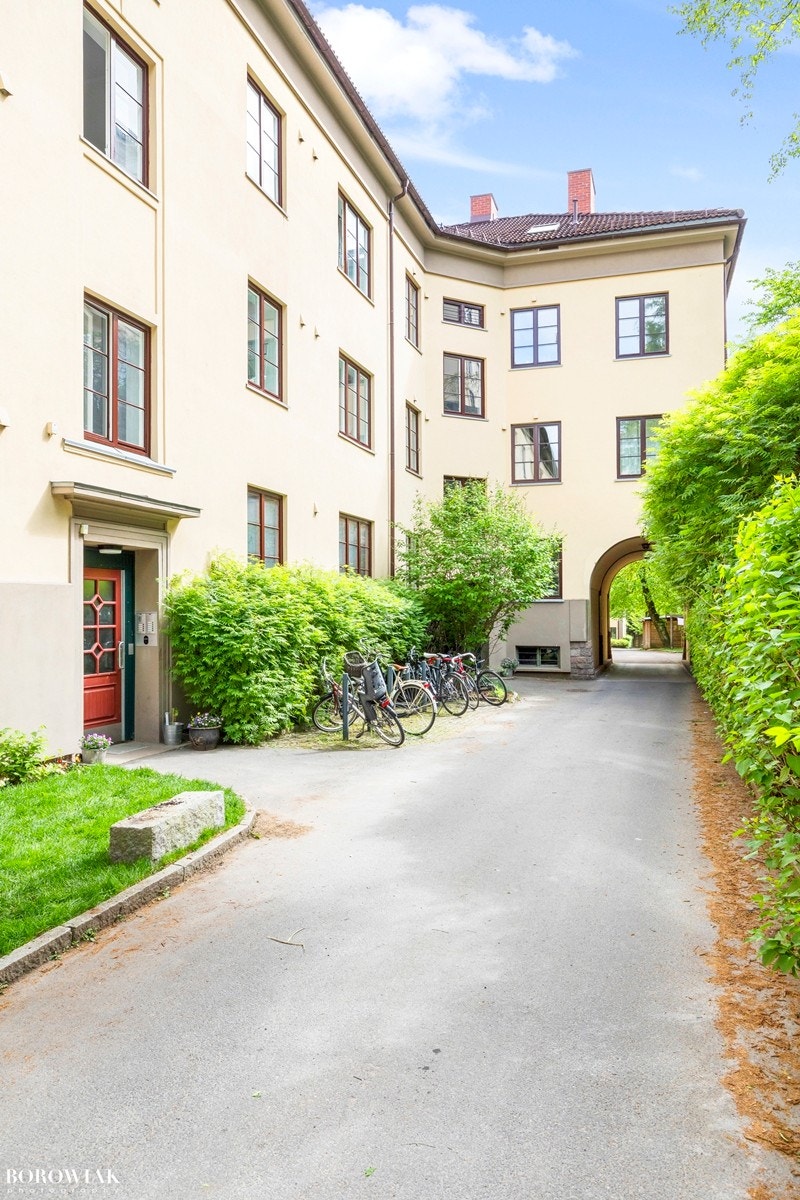 Pent opparbeidet fellesareal med plen og beplantning med bl.a. asfaltert internvei med lampebelysning, plen og trær. Galleribilde
