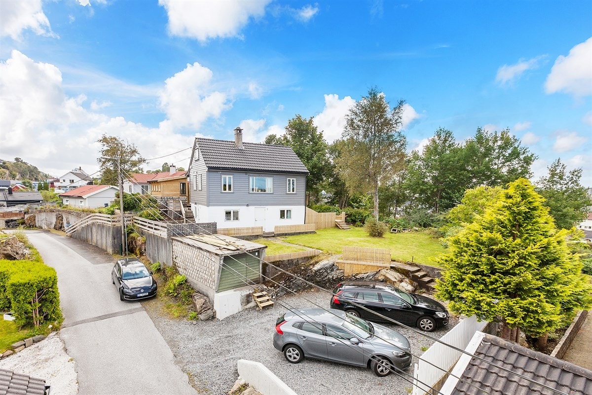 Tomten er opparbeidet med biloppstillingsplasser for biler på nedsiden av huset Galleribilde