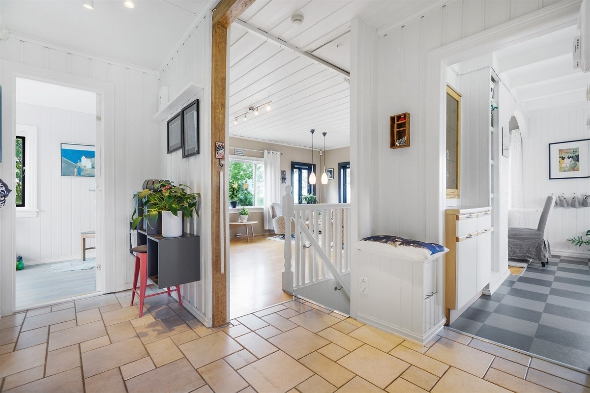 Velkommen inn! Den lyse og åpne gangen rommer plass til garderobeløsning for yttertøy. Flislagte gulv kommer godt med når man kommer hjem med våte sko og støvler Galleribilde