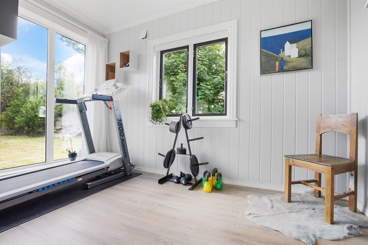 Soverom 2 benyttes i dag som et treningsrom, men kan enkelt innredes med seng, nattbord og garderobeløsning. Her er det verdt å merke seg vindusflatene som strekker seg fra gulv til tak Galleribilde