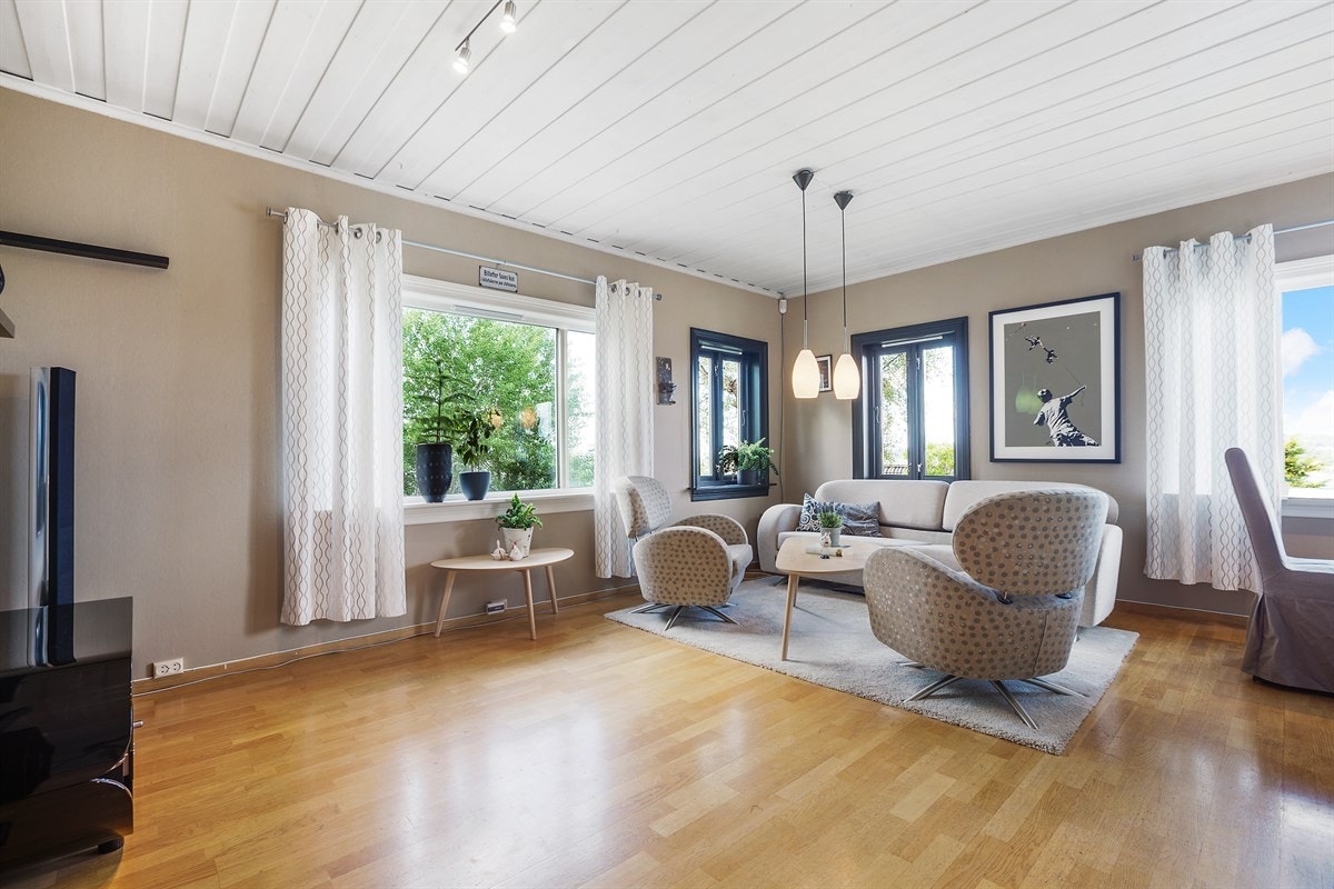 Det første du bemerker deg i oppholdsrommet er flere vindusflater som fyller rommet med dagslys og de behagelige fargene Galleribilde