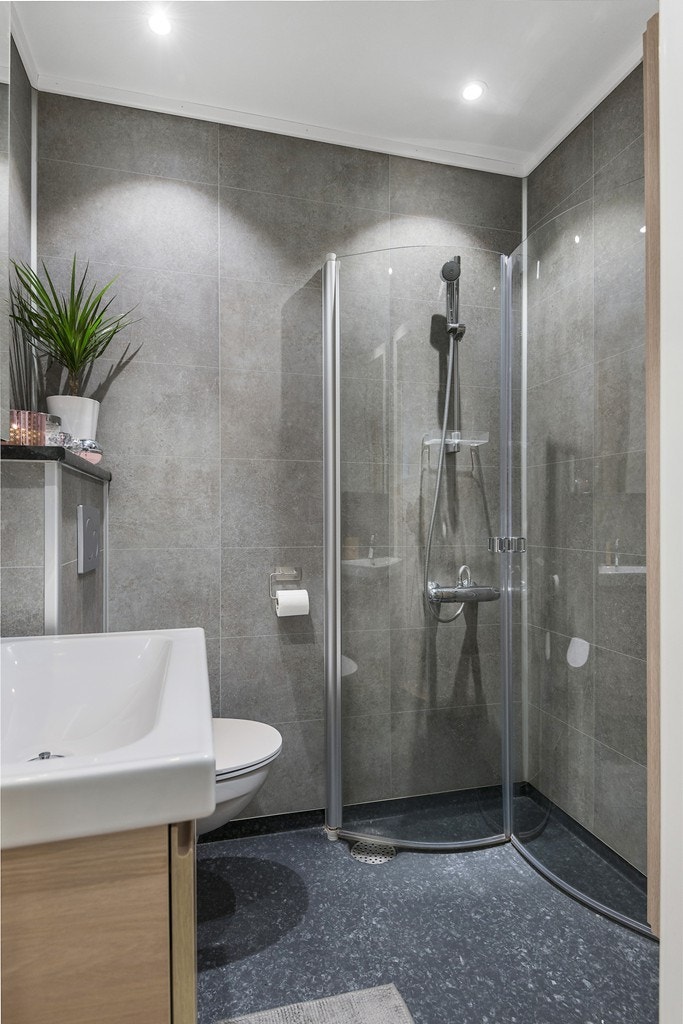 Dusjen er romslig innenfor de innsvingbare dusjdørene. Med nedsenket dusjområde i flisene behøver du heller ikke tenke på vann som flyter utenfor dusjsonen. Gled deg til en behagelig start og avslutning på dagen! Galleribilde