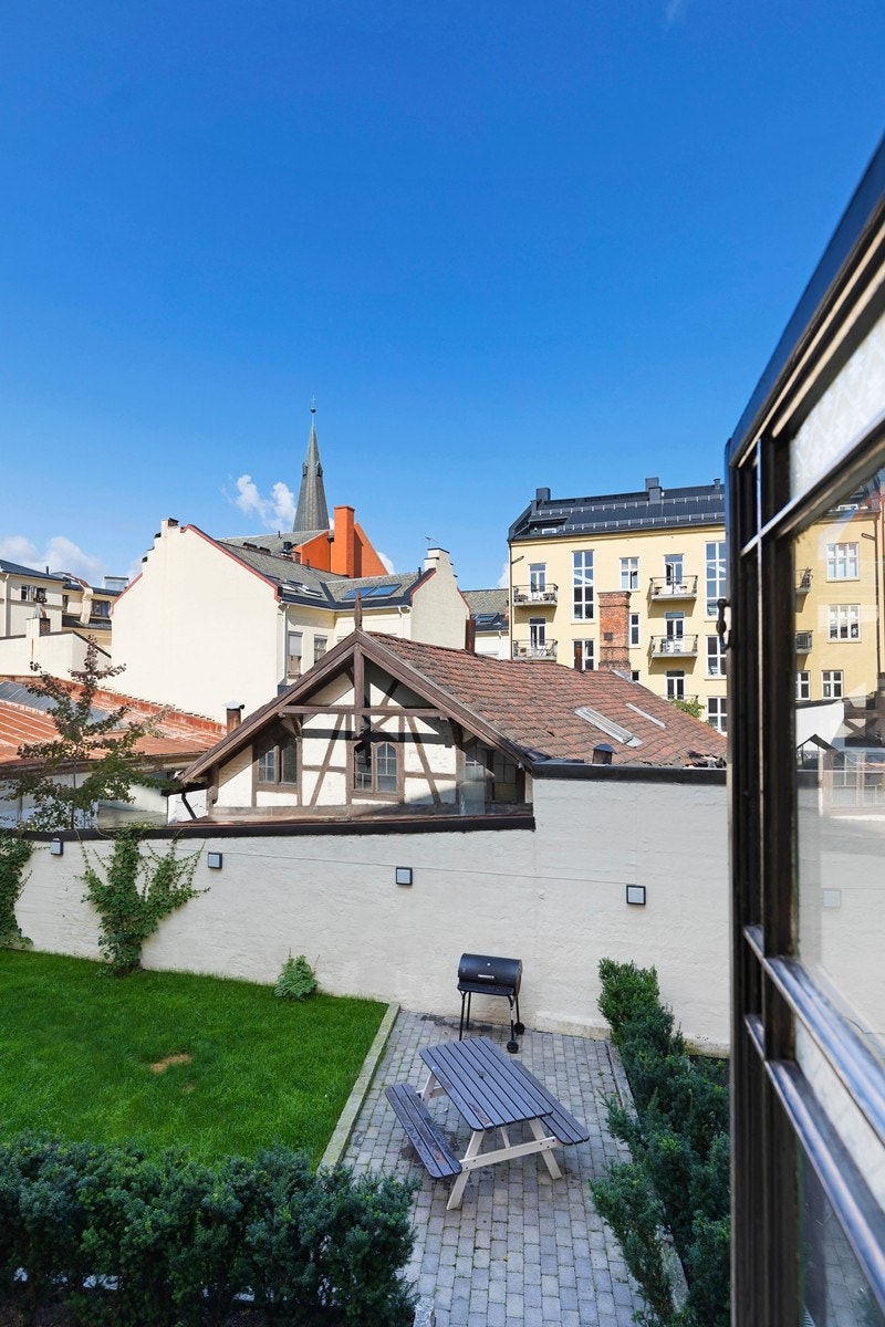 Sjeldent pent opparbeidet bakgårdshage. Parkmessig opparbeidet med prydbbusker, gressplen, brostein og sittegrupper. Galleribilde