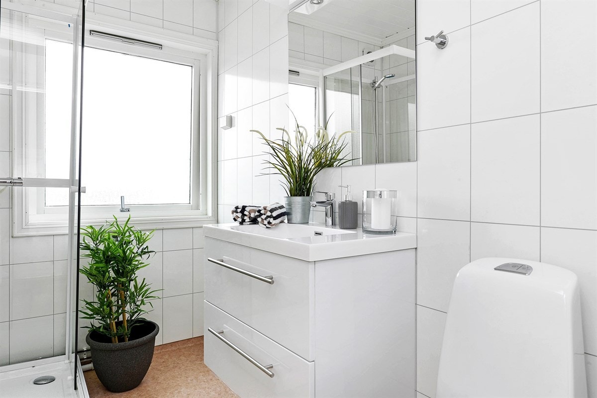 Badet har en innredningen bestående av skuffeseksjon med heldekkende servant og speil med belysning. Videre er det toalett, dusjkabinett og mulighet for vaskemaskin. Galleribilde