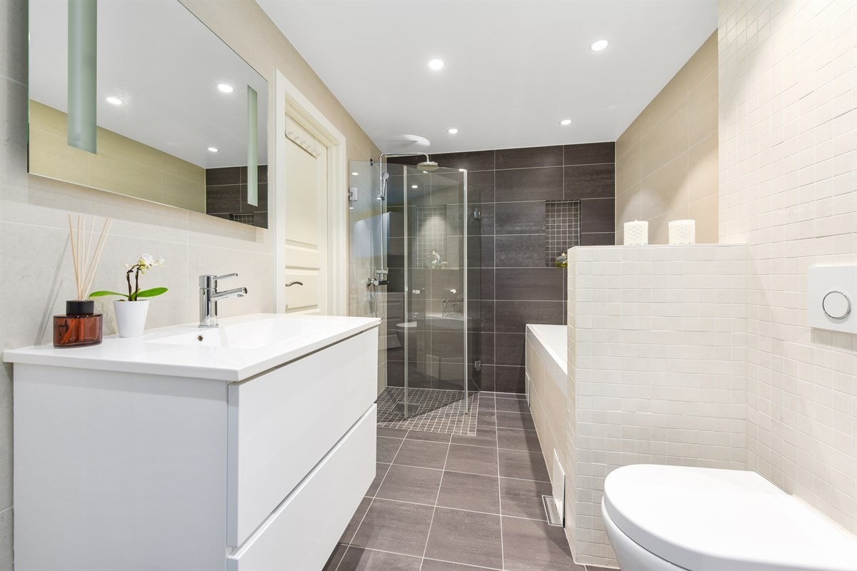 Innredning i hvit utførelse med heldekkende servant og ettgreps blandebatteri. Speil og belysning. Galleribilde