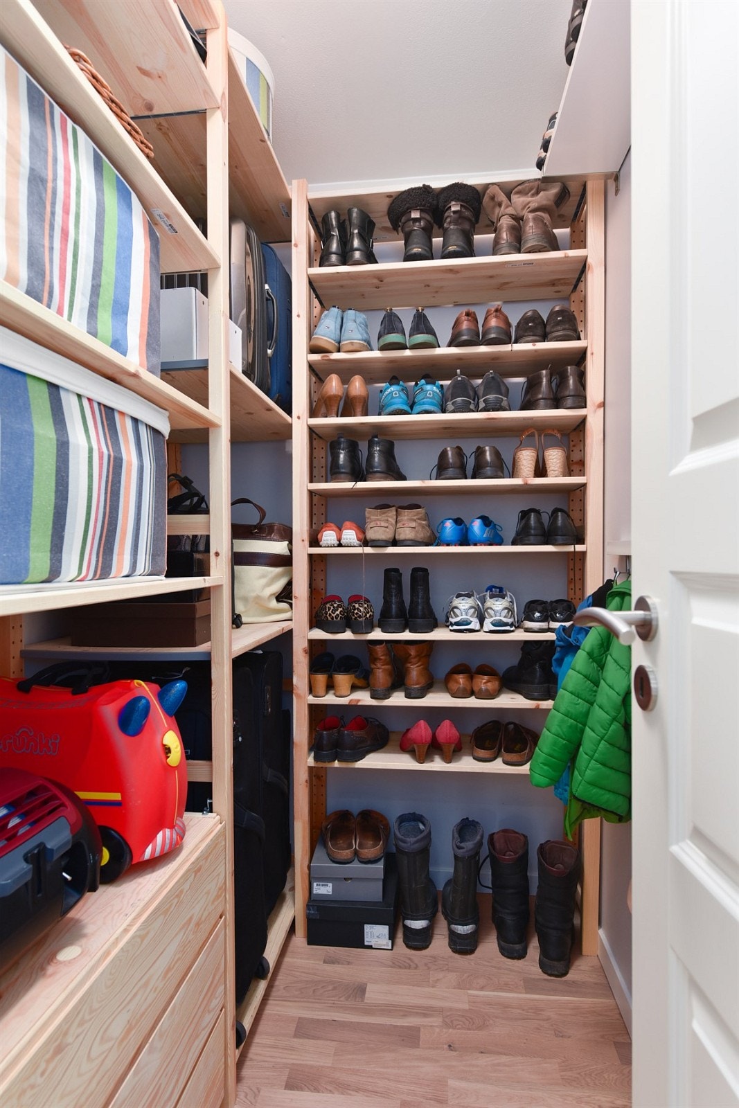 Adkomst fra gang til praktisk bod med diverse hyller for oppbevaring. Galleribilde