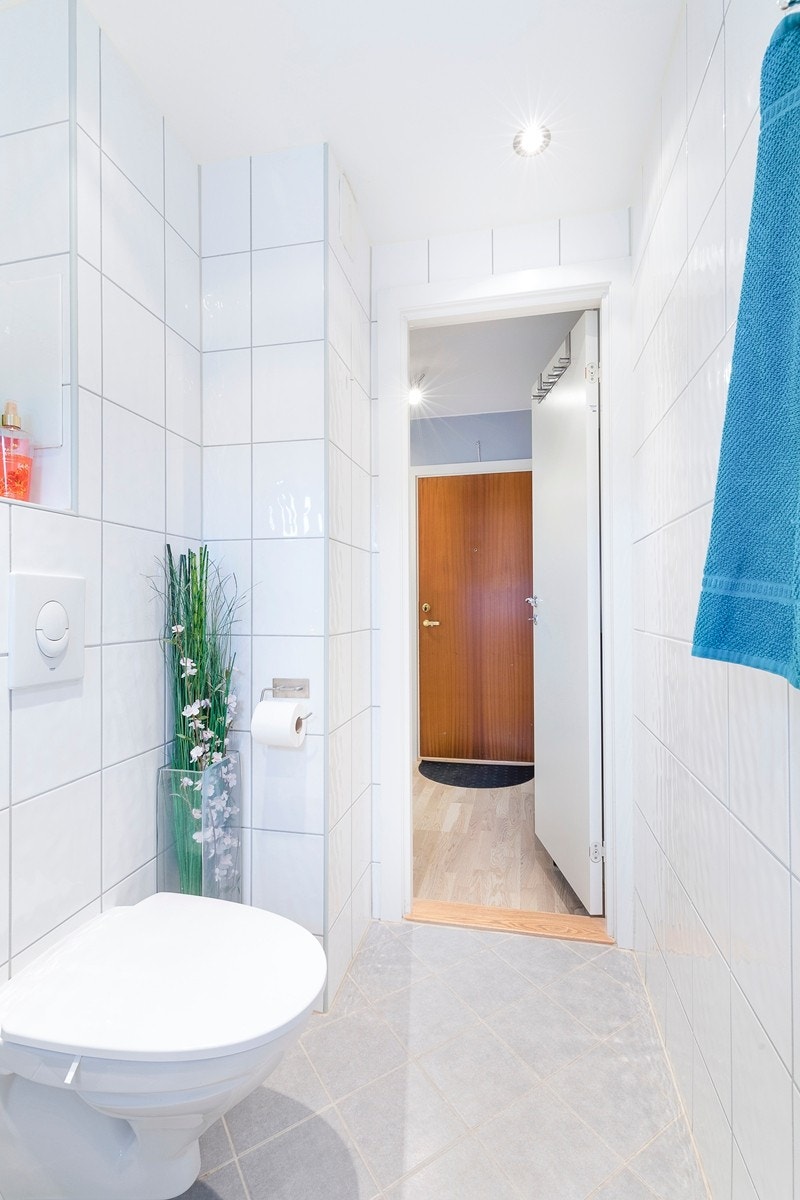 Badet har varmekabler i gulvet, fliser på veggene og malt himling med downlights Galleribilde