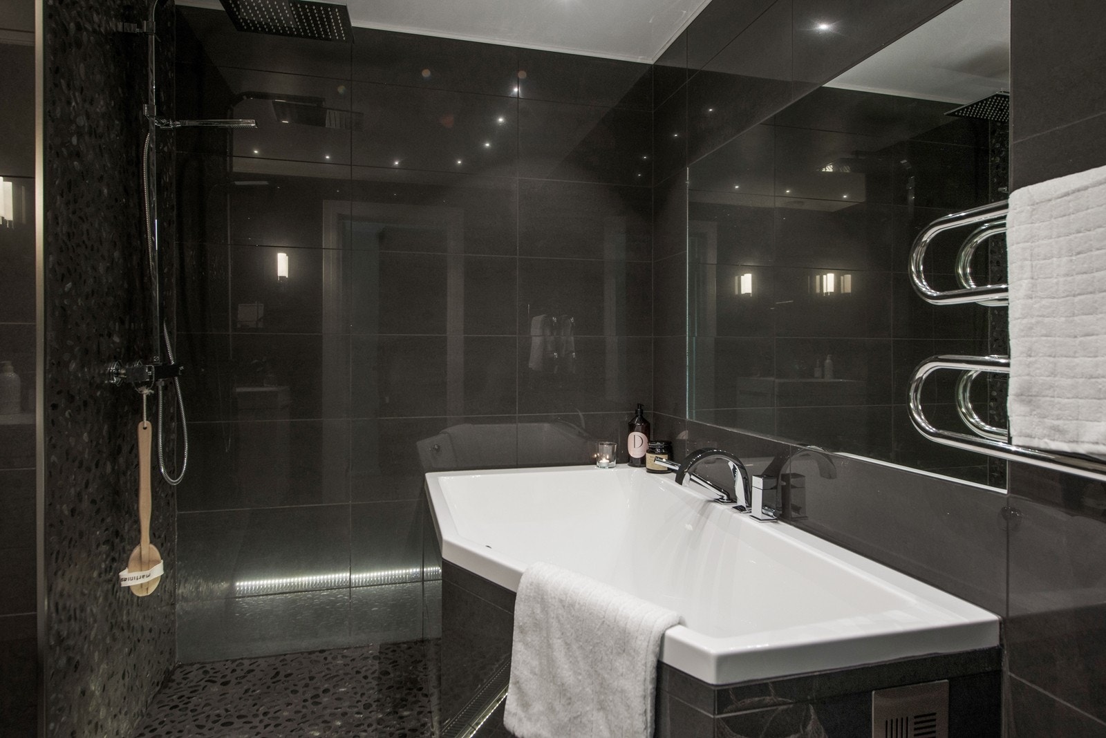 Flott spabad med innfelt speil i vegg, badekar og dusjnisje. Galleribilde