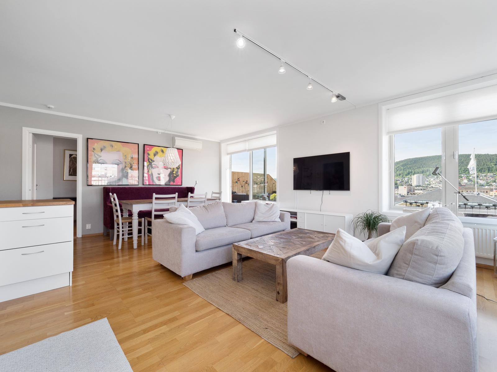 Stue med store vinduer og utgang til stor takterrasse i tillegg til balkong Galleribilde