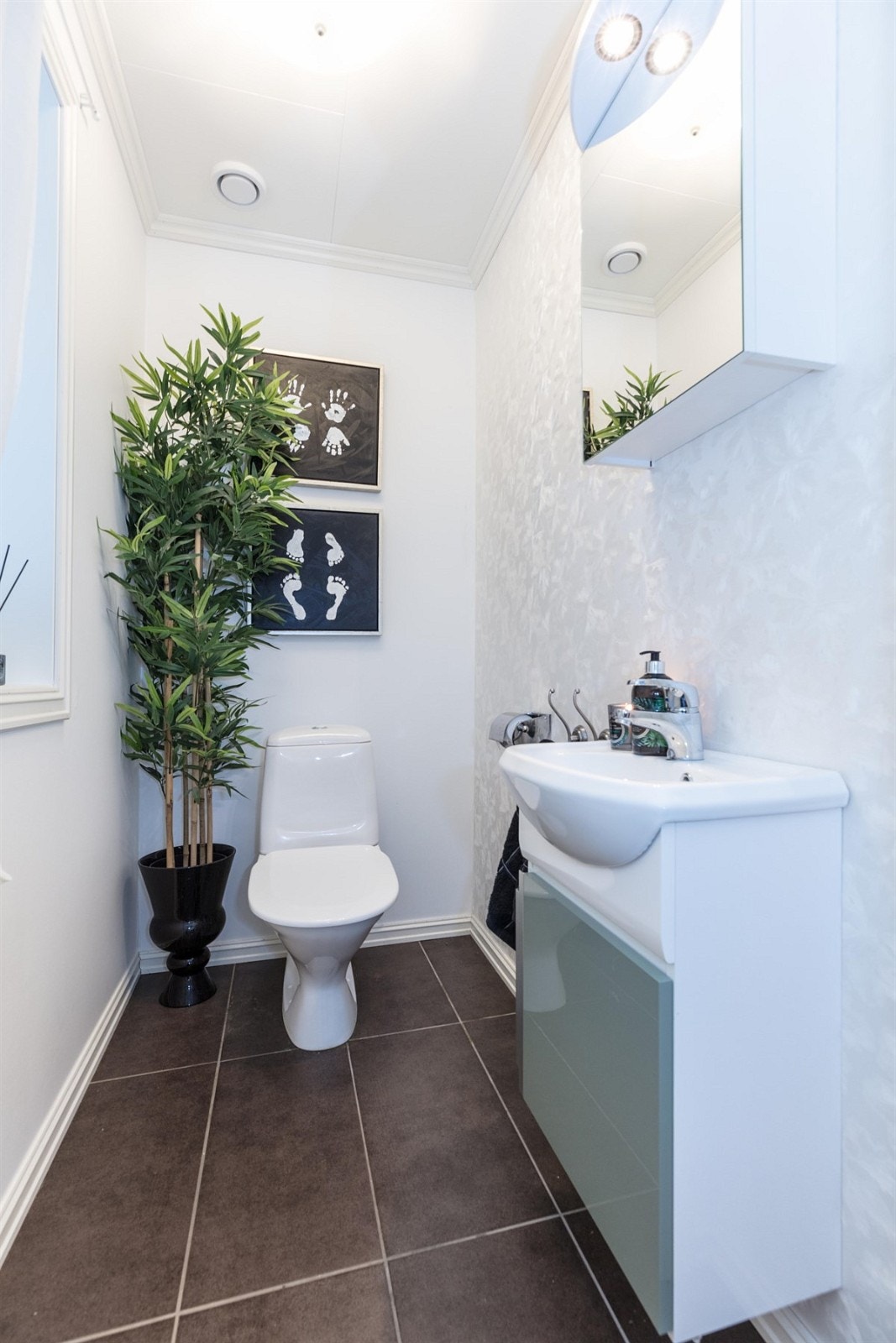 Boligen har et pent wc-rom i første etasje. Her er det fliser på gulv med underliggende gulvvarme og malte/tapetserte overflater. Innredningen besår av speilskap med toppmontert belysning, servant med underskap og frittstående toalett. Galleribilde