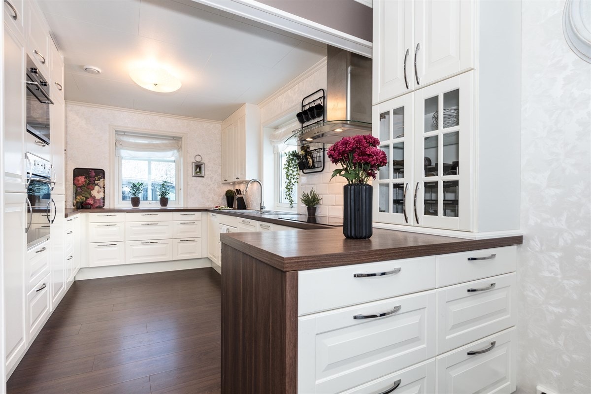 Lyst lekkert kjøkken i klassisk stil fra Ikea. Kjøkkenet er i åpen løsning mot stuen og fremstår som meget delikat og innbydende. Rommet har to store vinduer som gir rikelig med lys og bidrar til gode arbeidsforhold ved matlagingen. Galleribilde