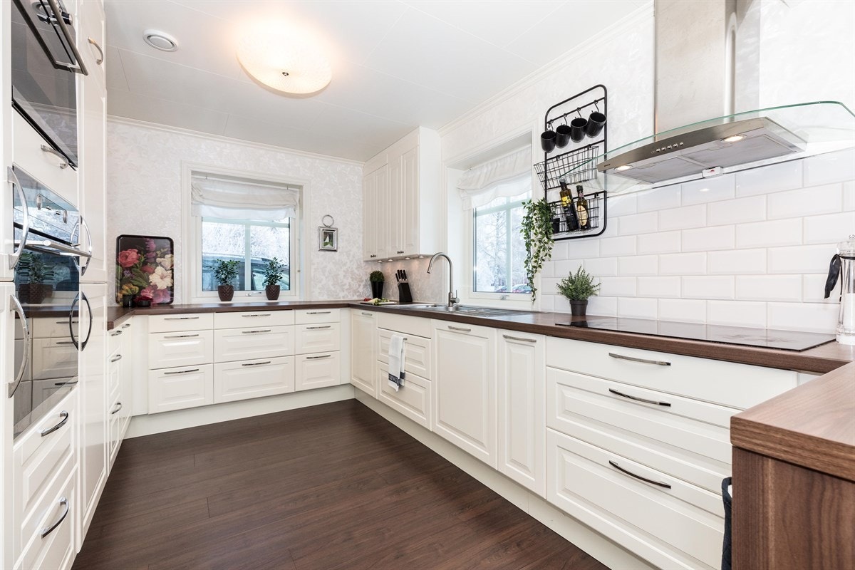 Innredningen har lyse, glatte og profilerte fronter med tilhørende opplyste vitrineskap. Benkeplaten er laminert i imitert trevirke og med nedfelt vaskekum. Galleribilde