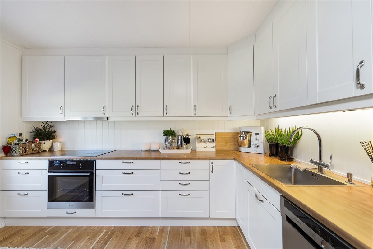 Kjøkkeninnredning i tidløs stil med takhøye skap og god arbeidsbenk. Galleribilde