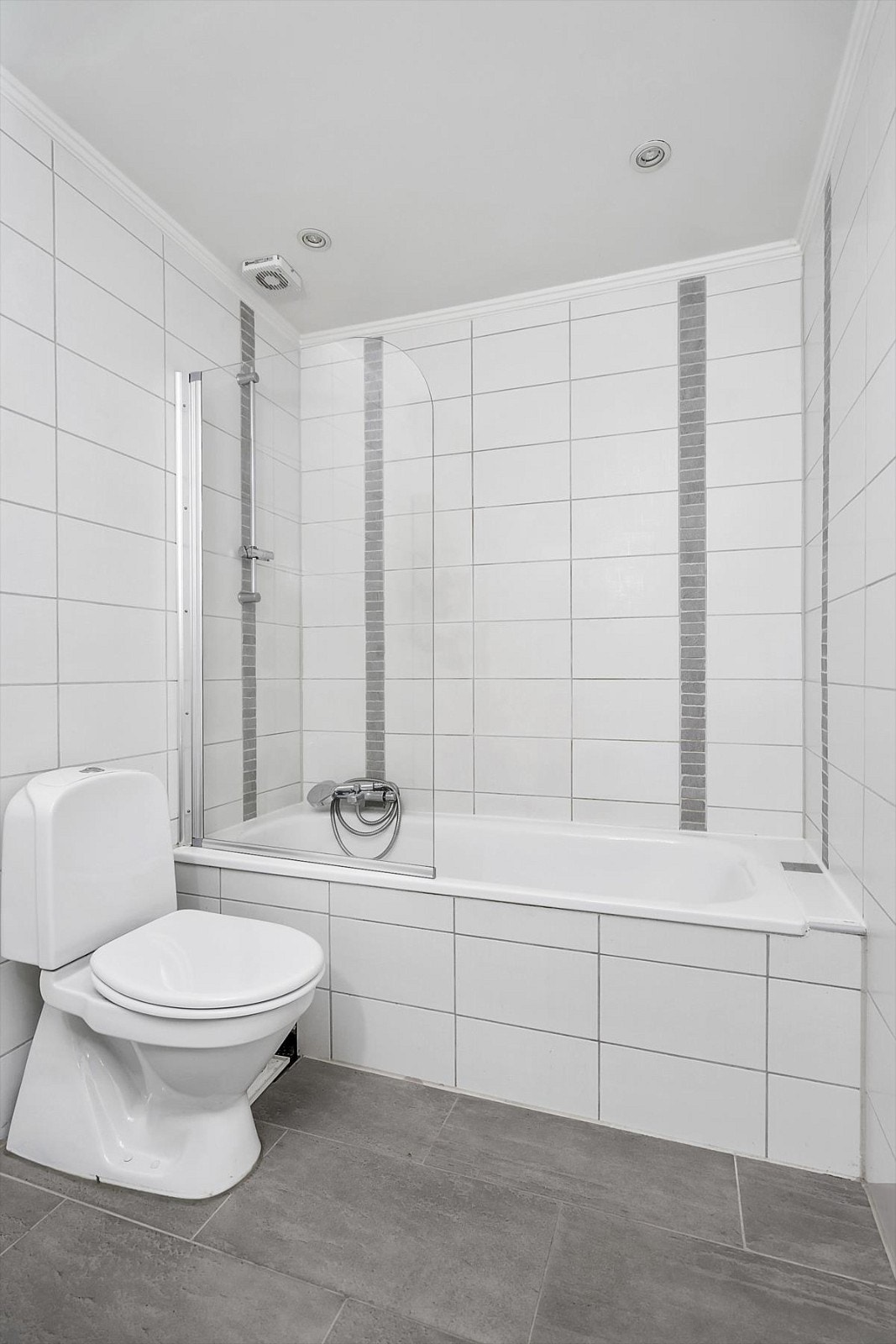 Badekar med dusjvegg, mekanisk avtrekk og spotter i taket. Galleribilde